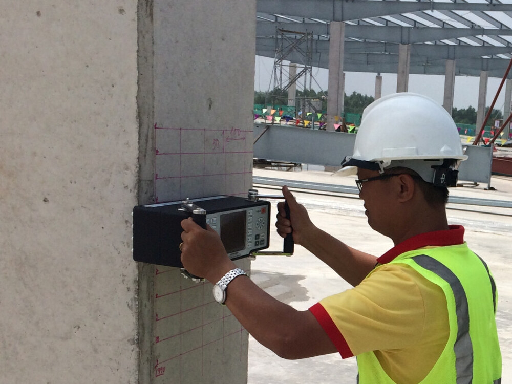Operator melakukan ultrasonic pulse-echo tomography pada kolom beton dengan A1040 MIRA Classic
