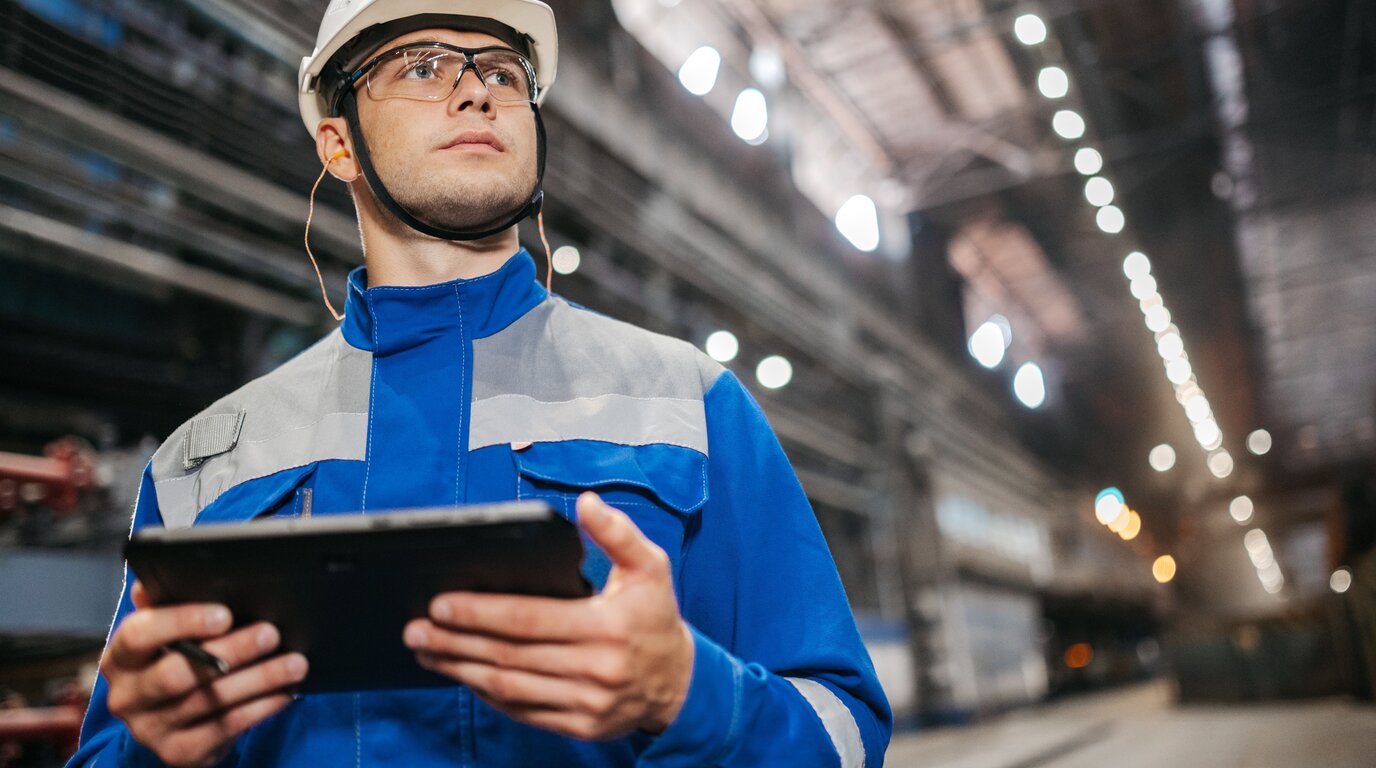 Engineer menggunakan tablet untuk monitoring dan inspeksi di fasilitas industri