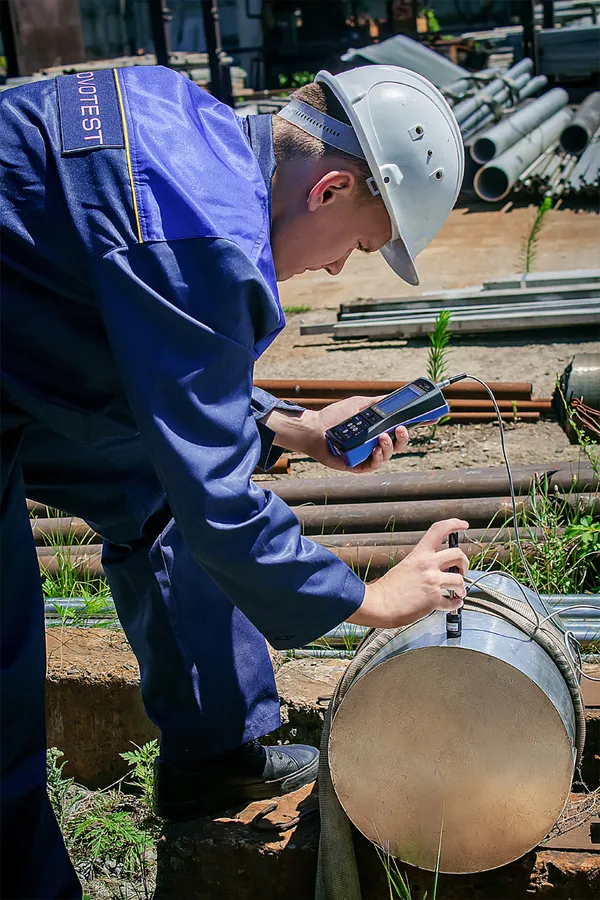 Operator menggunakan Leeb hardness tester NOVOTEST pada komponen logam besar di lapangan